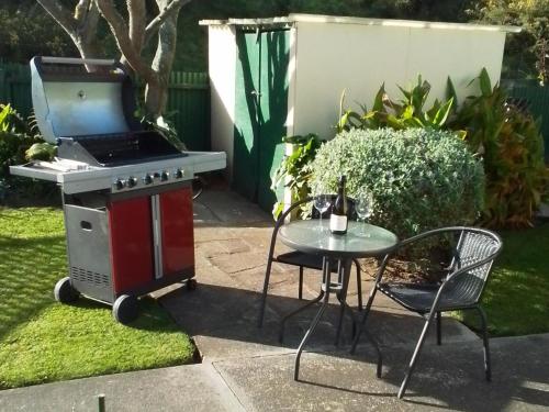 a grill and a table and a table and a chair at Celtic Motel in Foxton