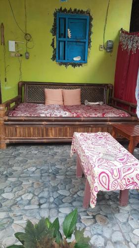 Schlafzimmer mit einem Bett, einem Tisch und einem Fenster in der Unterkunft Red Beach Homestay in Pasanggaran