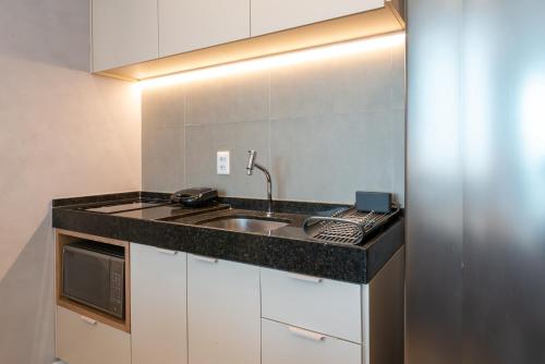 a kitchen with a sink and a microwave at Flat luxo em Boa Viagem Rooftop 201 in Recife