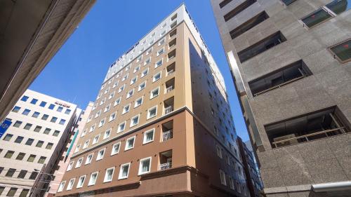 a tall building in the middle of two buildings at Toyoko Inn Kayabacho Eki in Tokyo