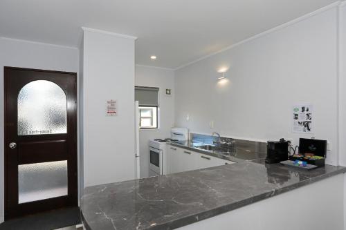 a white kitchen with a counter top and a counter top at Hacienda Motor Lodge in Palmerston North