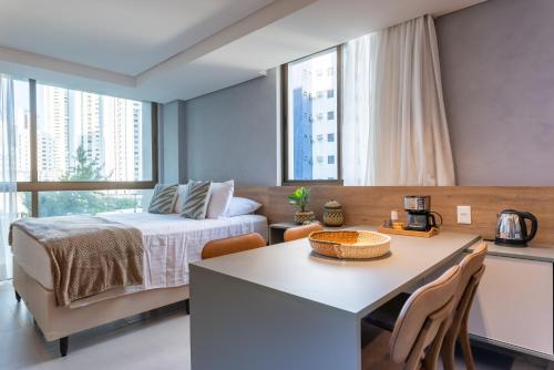 a bedroom with a bed and a table with chairs at Flat de luxo Rooftop 201 in Recife