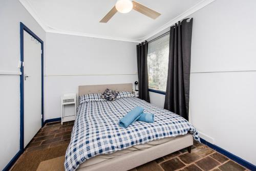 1 dormitorio con 1 cama con almohadas azules en Gone Coastal en Lancelin