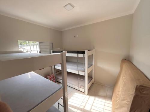 a small room with a bunk bed and a desk at Recanto das Palmeiras - área de lazer em São Carlos in São Carlos