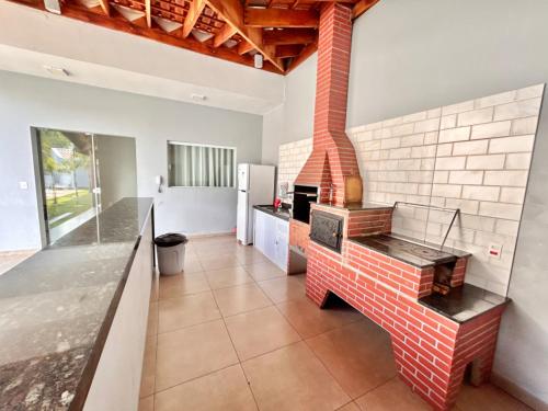 uma cozinha com um fogão de tijolos num quarto em Recanto das Palmeiras - área de lazer em São Carlos em São Carlos