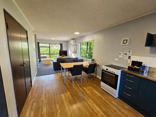 een keuken en een woonkamer met een tafel en stoelen bij Hacienda Motor Lodge in Palmerston North