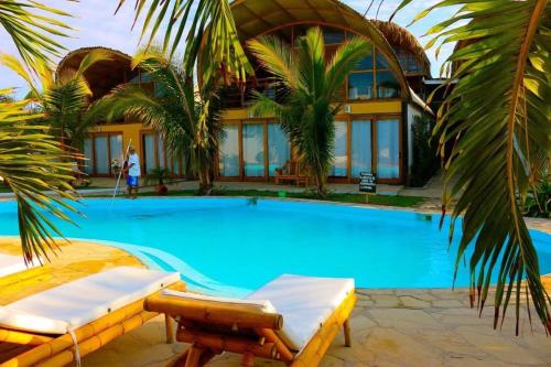 een zwembad met 2 ligstoelen voor een huis bij Kites Mancora in Máncora