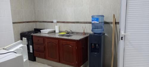 a small kitchen with a stove and a water dispenser at Cabañas Don Tatin in La Banda