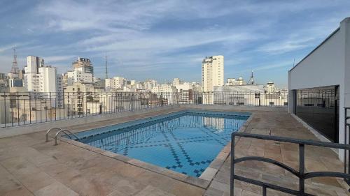 a swimming pool on the roof of a building at Flat Saint Paul Jardim Paulista Magnifico! in Sao Paulo