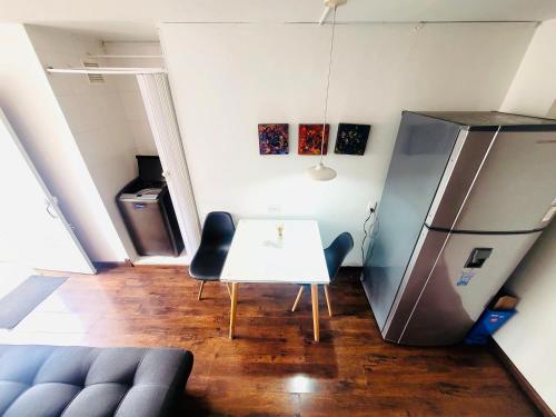 a kitchen with a white table and a refrigerator at Hostel Usaquen Bogota in Bogotá