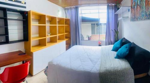 Dormitorio con cama, escritorio y TV en Hostel Usaquen Bogota, en Bogotá