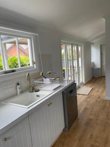 a white kitchen with a sink and a window at Character 1920s 3 bedroom bungalow in Cambridge