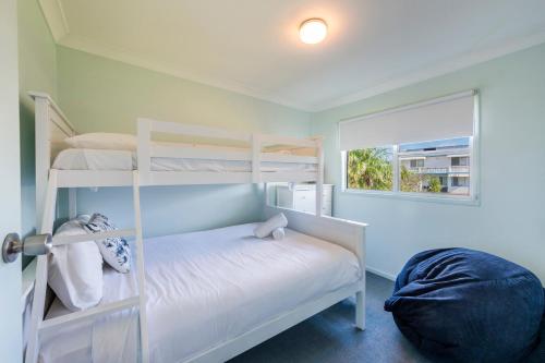 1 dormitorio con 2 literas y ventana en At The Beach Brooms Head-LJHooker Yamba, en Brooms Head