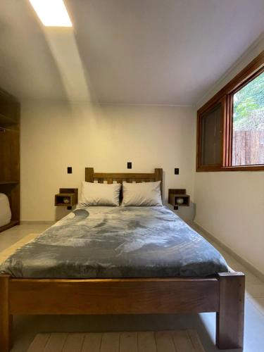 - une chambre avec un grand lit et une fenêtre dans l'établissement CASA DA FONTE, à Bento Gonçalves
