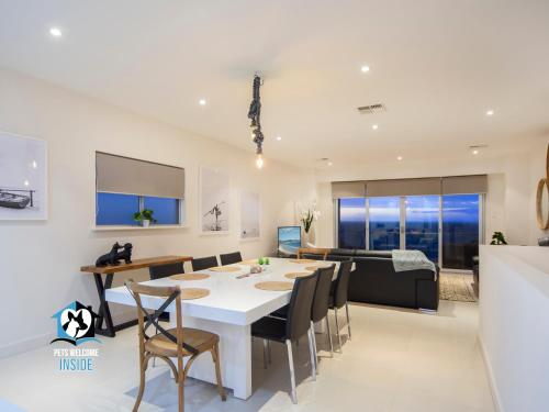 a dining room and living room with a table and chairs at Spectacular Esplanade 4BR Contemporary with Views in Aldinga Beach