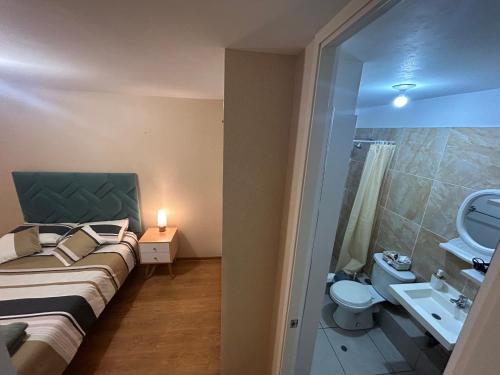 a bedroom with a bed and a sink and a toilet at Acogedor apartamento centrico, tranquilo con piscina in Lima