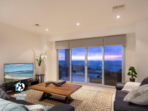 a living room with a couch and a large window at Spectacular Esplanade 4BR Contemporary with Views in Aldinga Beach