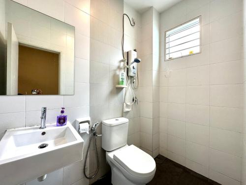 y baño con aseo blanco y lavamanos. en BNB Casa Grande at Rawang - spacious, 15 pax and WiFi, en Rawang