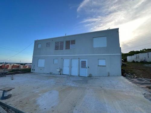 ein großes weißes Gebäude mit zwei Garagentüren in der Unterkunft OceanView 2 in Guayama
