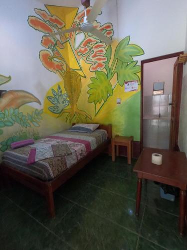 a bedroom with a painting on the wall at El Curichal Hostel in Rurrenabaque