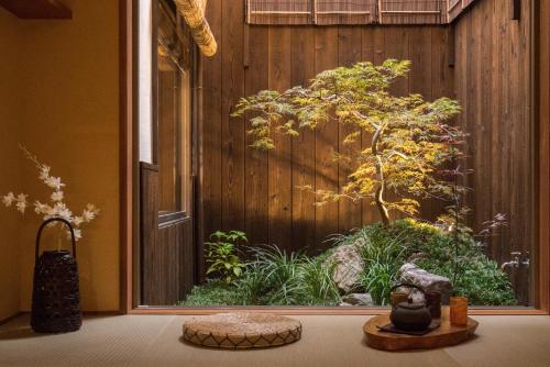 Habitación con una gran ventana con un árbol en el exterior en 京町　朱雀 en Kyoto