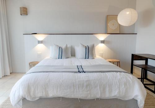 a bedroom with a large white bed with blue pillows at Hillcrest Merimbula in Merimbula