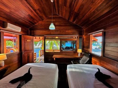 two black birds sitting on top of two beds in a room at Andau Resort Raja Ampat in Tapokreng