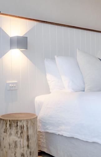 a bedroom with a bed and a wooden stump next to a table at Hillcrest Merimbula in Merimbula