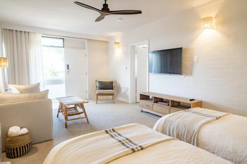 a hotel room with two beds and a flat screen tv at Hillcrest Merimbula in Merimbula