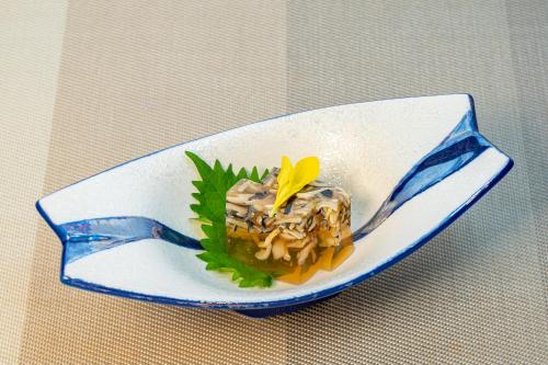 a plate with a piece of food on a fork at Ishinoya Izunagaoka - TKP Hotels & Resorts in Izunokuni