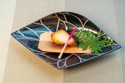 a piece of food on a plate on a table at Ishinoya Izunagaoka - TKP Hotels & Resorts in Izunokuni