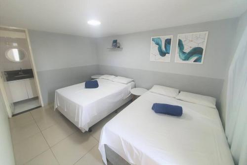2 camas en una habitación con paredes blancas en Flat Premium - Bessa - Praticamente Beira Mar, en João Pessoa