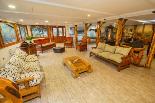 a living room with couches and chairs and a table at Santuario del Río in San José de Maipo