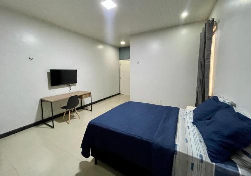 Dormitorio con cama, escritorio y TV en Casa completa, suíte master com closet en Macapá