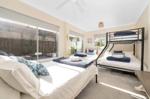 a bedroom with two bunk beds and a window at The Rotunda, Gerroa in Gerroa