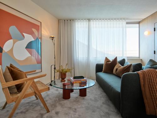 a living room with a blue couch and a glass table at Oxford House in Sydney