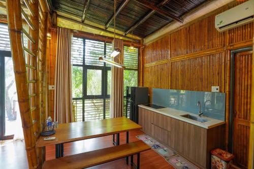 a kitchen with wooden walls and a table and a sink at LITTLE BEE HOUSE in Trại Vang