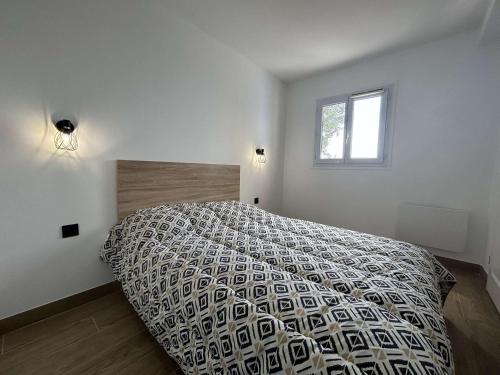 une chambre avec un lit avec une couette et une fenêtre dans l'établissement Appartement climatisé 2 pièces avec piscine et parking sécurisé - FR-1-226-524, à Roquebrune-sur Argens