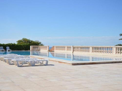 - une piscine bordée de tables et de chaises dans l'établissement Appartement climatisé 2 pièces avec piscine et parking sécurisé - FR-1-226-524, à Roquebrune-sur Argens