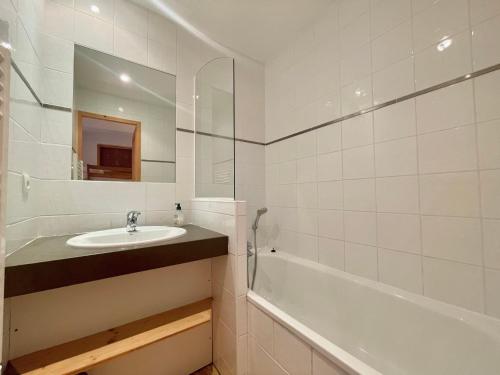 a bathroom with a sink and a tub and a mirror at Charmant duplex 6 pers au cœur du village avec piscine et parking - FR-1-505-192 in Notre-Dame-de-Bellecombe