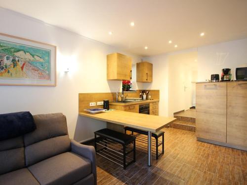 une cuisine et un salon avec une table et un canapé dans l'établissement Charmant T2 au Mont-Dore, 38m², proche thermes, terrasse et wifi, résidence calme, parking à proximité - FR-1-608-252, à Le Mont-Dore