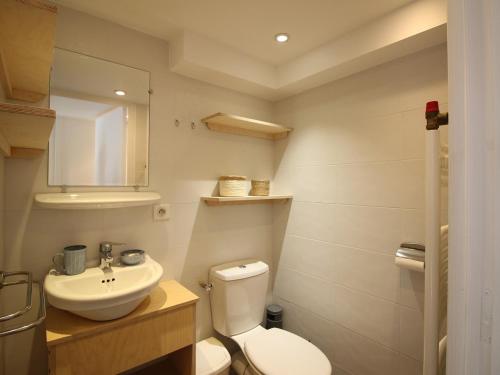 une salle de bain avec des toilettes blanches et un lavabo dans l'établissement Charmant T2 au Mont-Dore, 38m², proche thermes, terrasse et wifi, résidence calme, parking à proximité - FR-1-608-252, à Le Mont-Dore