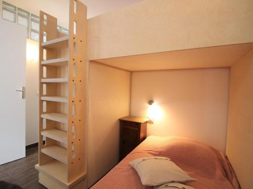 une chambre avec un lit superposé avec une échelle dans l'établissement Charmant T2 au Mont-Dore, 38m², proche thermes, terrasse et wifi, résidence calme, parking à proximité - FR-1-608-252, à Le Mont-Dore