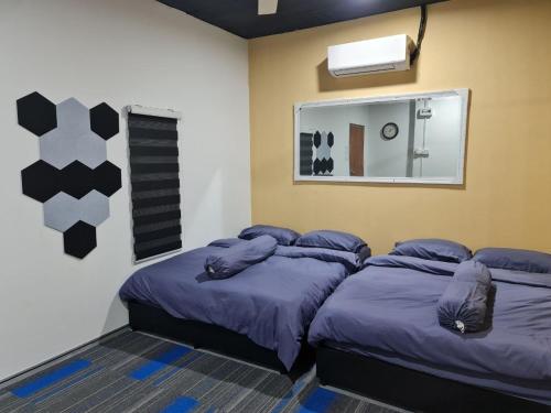 a bedroom with two beds and a mirror at Ayden Hostel Airport Transit - KLIA in Sepang