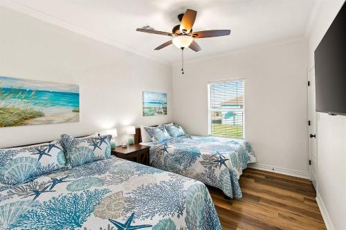 a bedroom with two beds and a ceiling fan at The Breezy Turtle in Crystal Beach