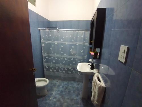 een blauwe badkamer met een wastafel en een toilet bij Cabaña San Cayetano v&g in San Rafael