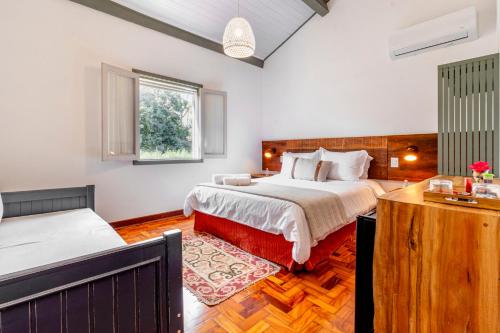 a bedroom with a large bed and a window at Limoeiro da Concórdia Hotel Fazenda de Charme in Itu