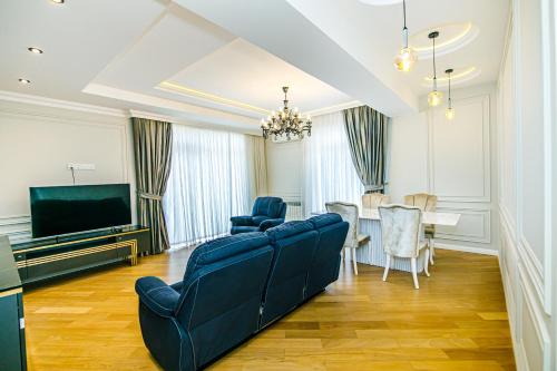 a living room with a couch and a tv and a table at Baku Sea View 3 bedroom in Baku