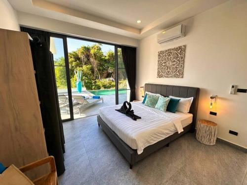 Un dormitorio con una cama grande y una ventana grande. en VILLA CHLOE - SEAVIEW - 4 Bedrooms, en Koh Samui 