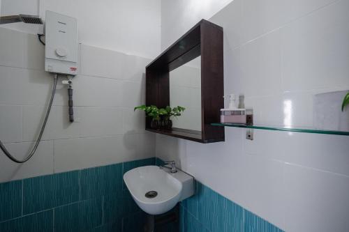 bagno con servizi igienici, lavandino e specchio di Swiss Cottage Tioman a Isola di Tioman